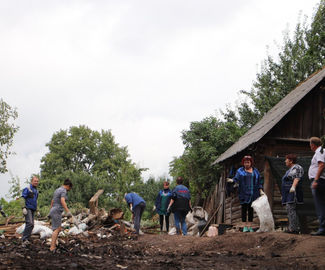 На зарайской улице Кремлёвский спуск возле одного из домов наводят порядок.